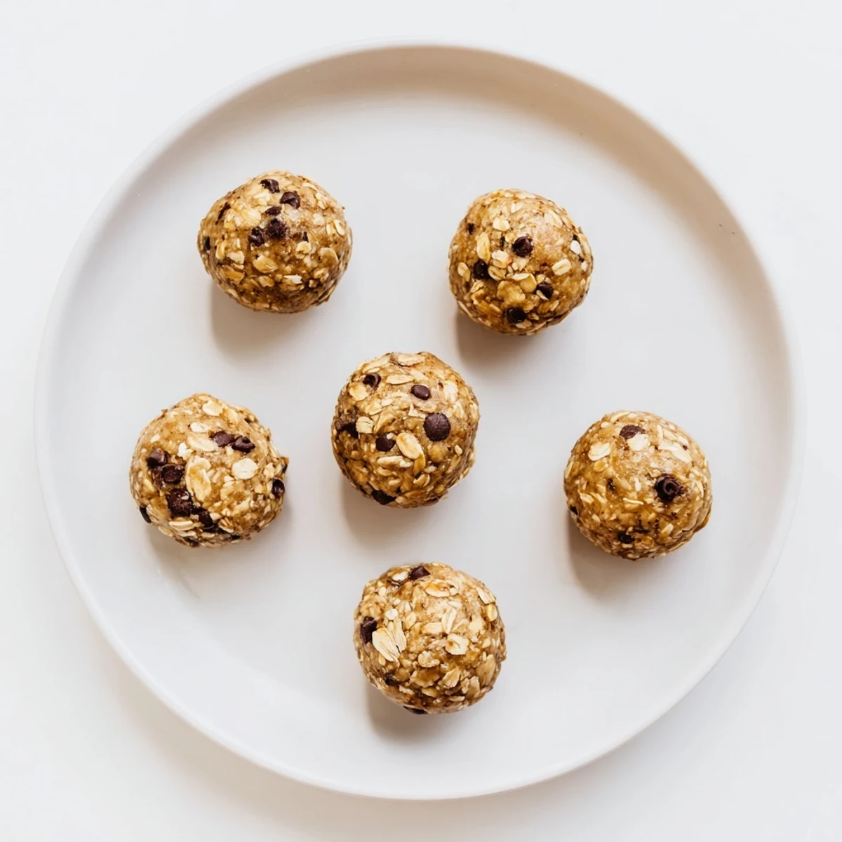 Green-tinged mint chocolate chip protein balls arranged on a serving tray for healthy snacking