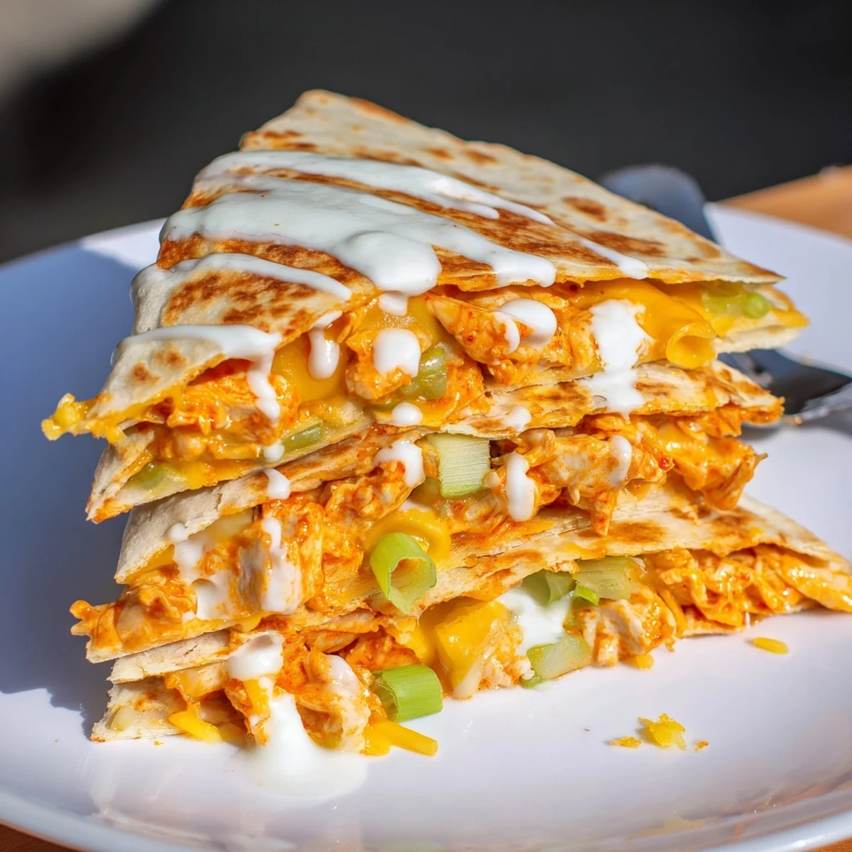 Savory buffalo chicken quesadilla with cooling ranch sauce on wooden serving board
