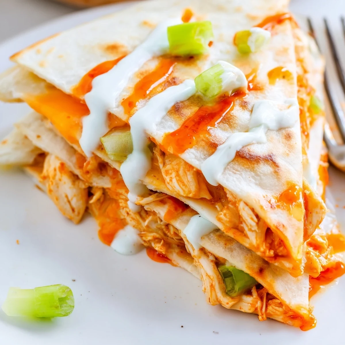 Spicy buffalo chicken and melted cheese oozing from warm flour tortilla half