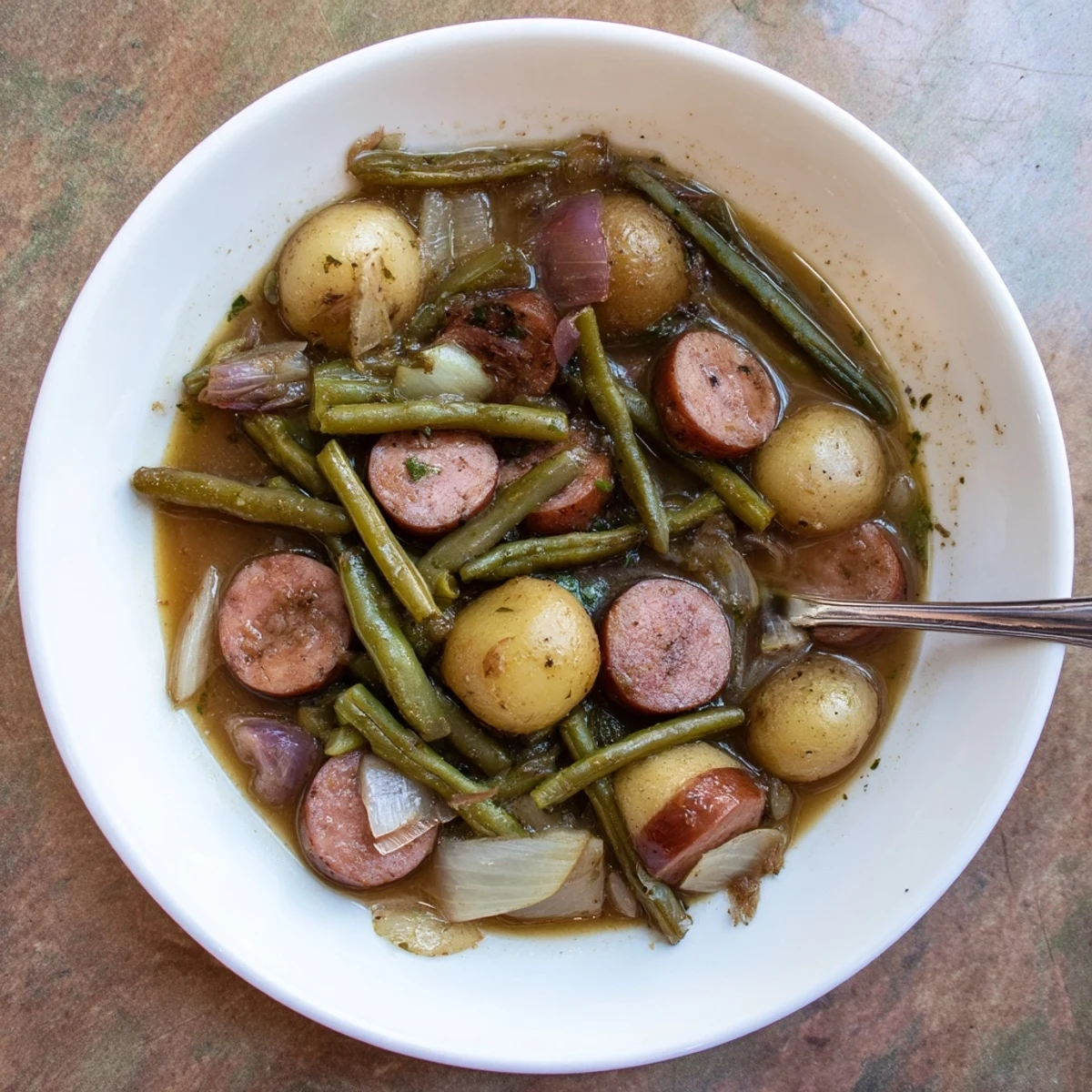 Golden brown Crockpot Kielbasa and Green Beans served in a bowl with steam rising from this hearty, flavorful slow-cooked dish