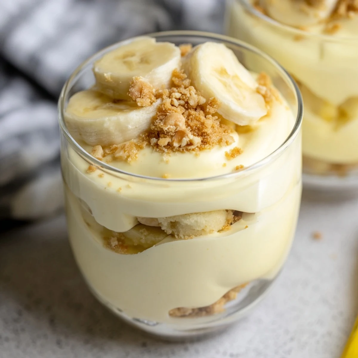 Creamy banana pudding cheesecake cups layered with fresh banana slices and vanilla wafer crumbs