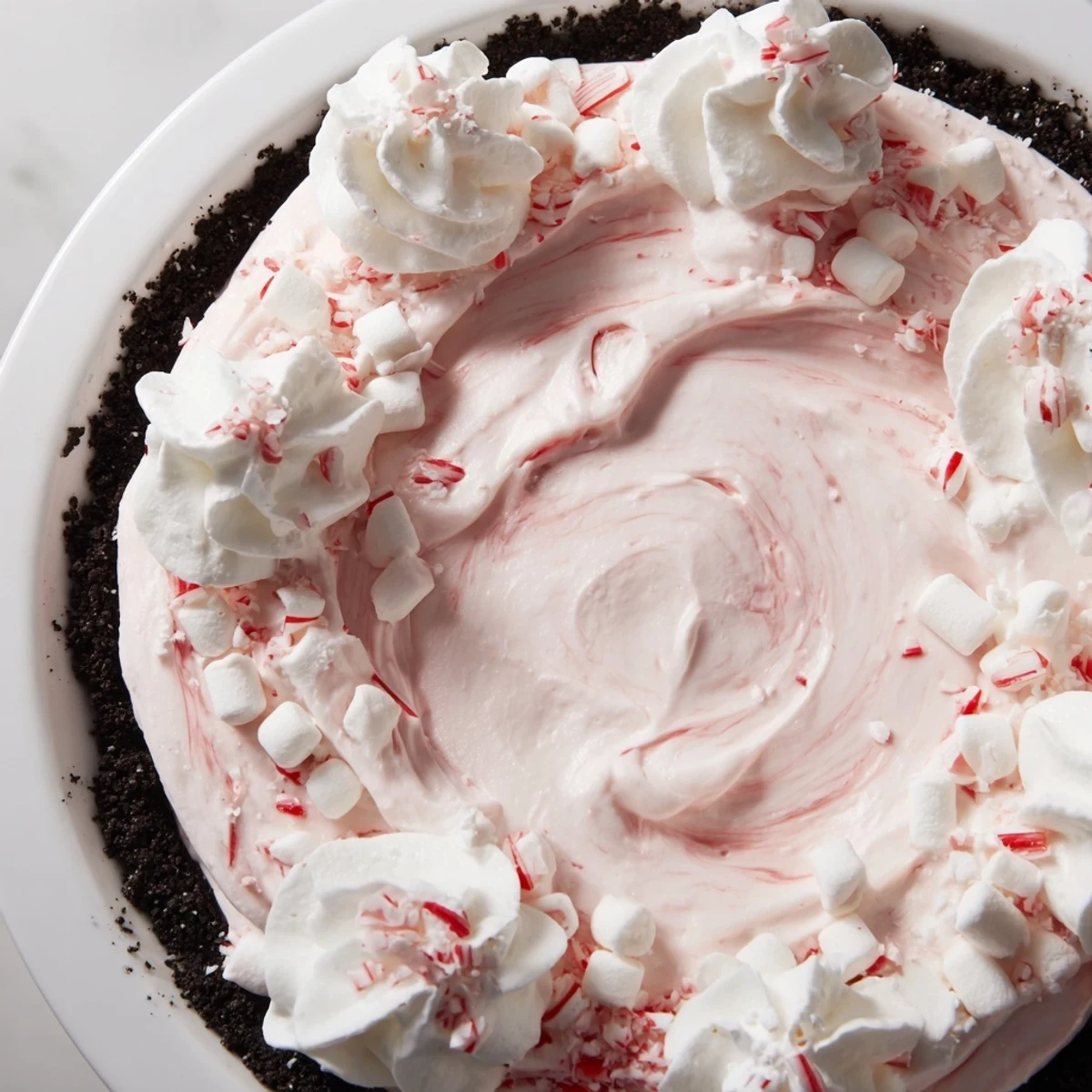 Slice of Candy Cane Pie garnished with whipped cream, chilled and festive
