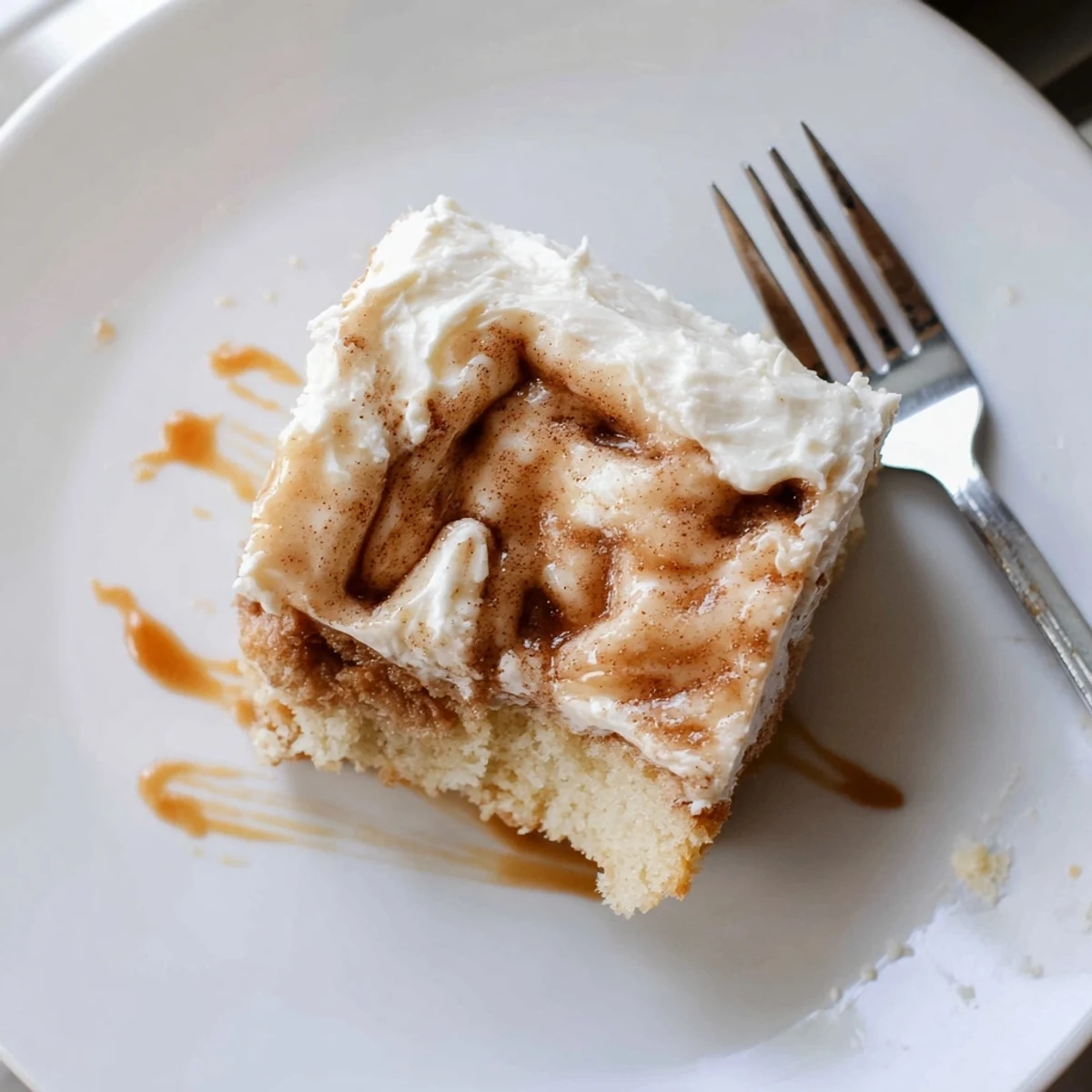 Cinnamon Roll Poke Cake with gooey cinnamon pockets and cream cheese frosting
