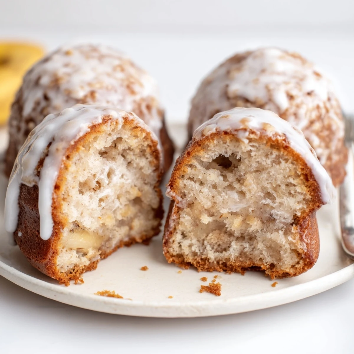 Moist, fluffy Banana Donuts with cinnamon aroma, glazed and cooling on rack.