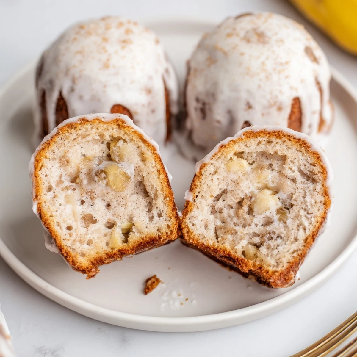 Golden baked Banana Donuts piled on plate, perfect with morning coffee.