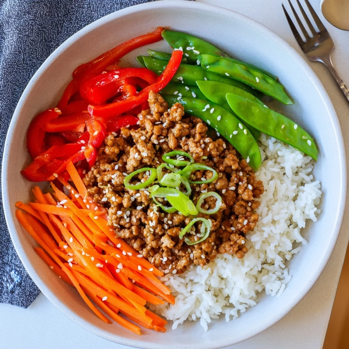 Steaming Teriyaki Turkey Rice Bowls topped with sesame seeds and bright bell pepper