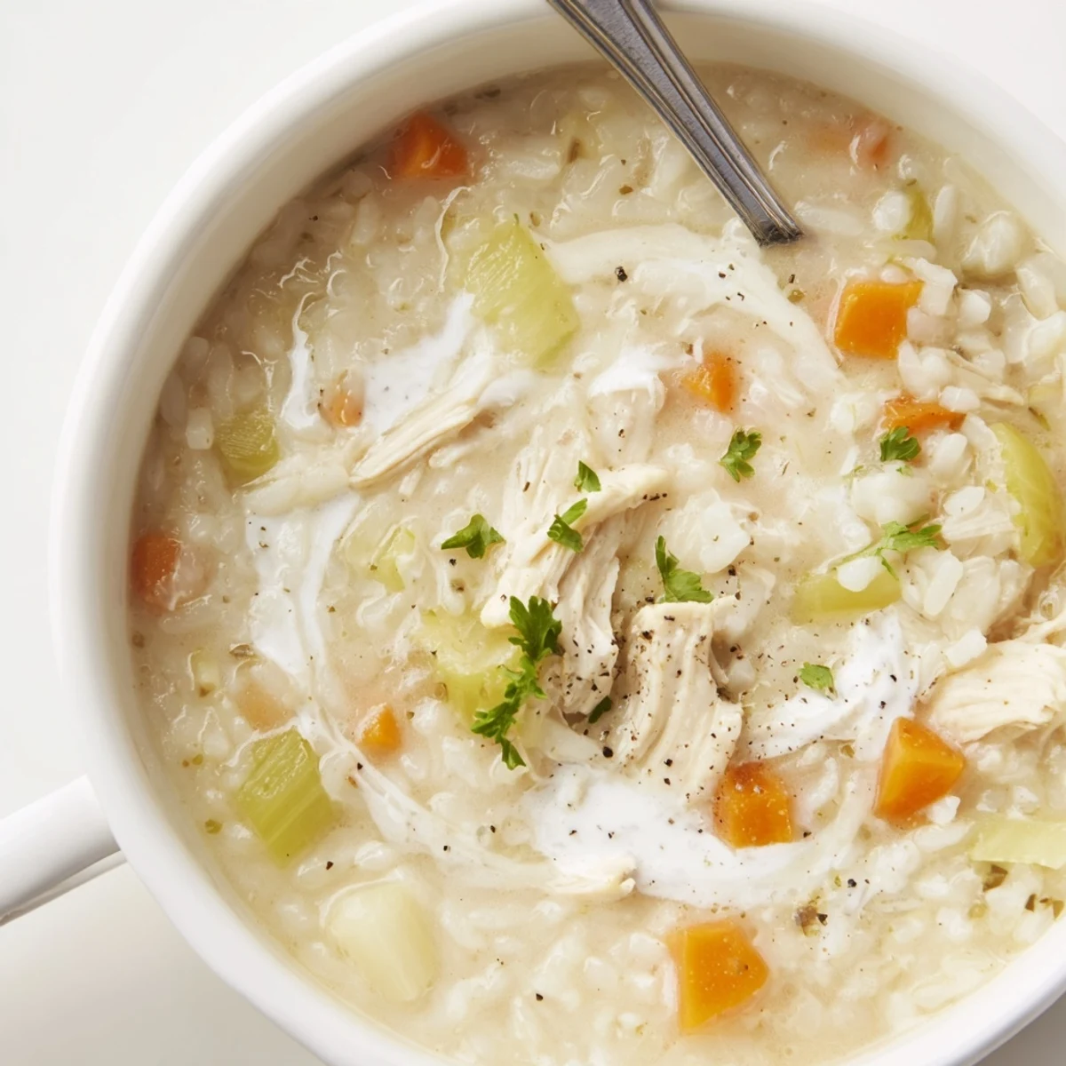 Bowl of Creamy Chicken Rice Soup with tender grains, carrots, and crusty bread