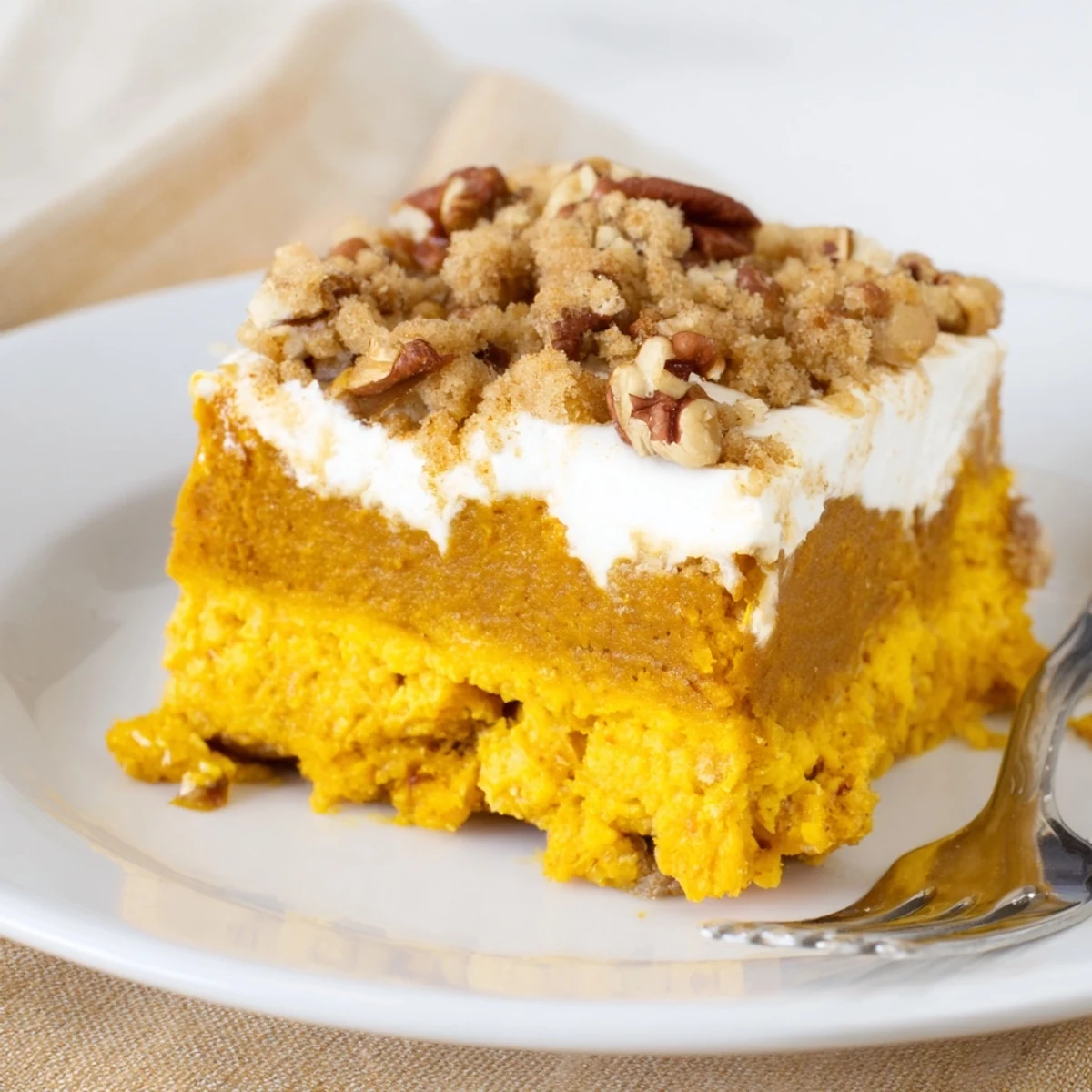 Warm Pumpkin Dump Cake with golden pecan topping and vanilla ice cream