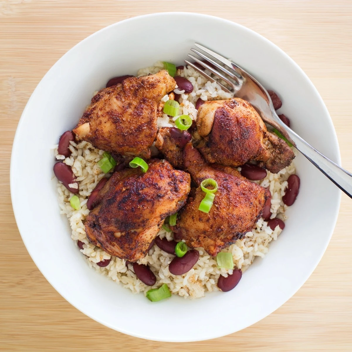 Golden brown jerk-marinated chicken thighs served over fluffy coconut rice with red kidney beans