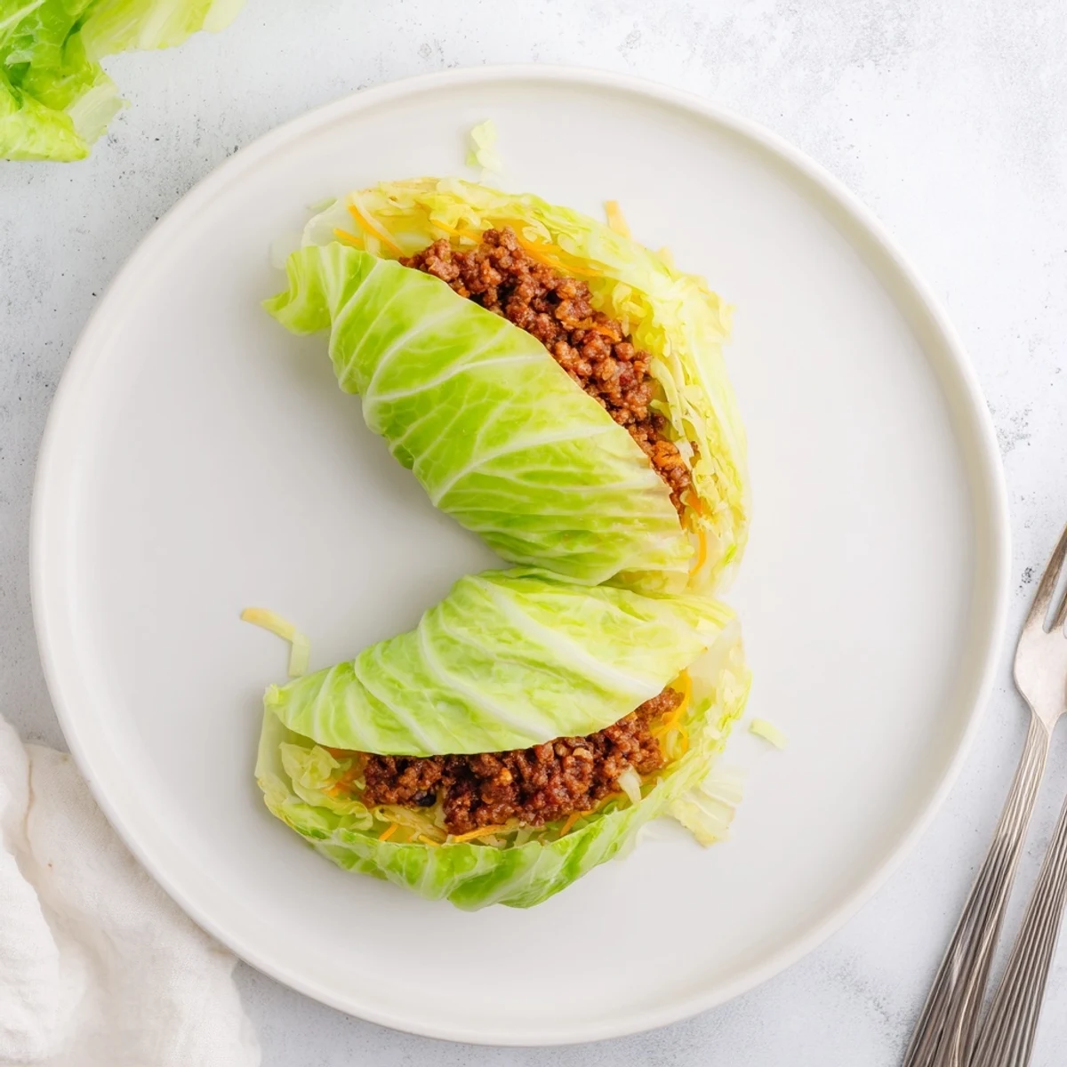 Juicy oven baked cabbage burger with melted cheddar nestled inside steamed cabbage leaf wrap