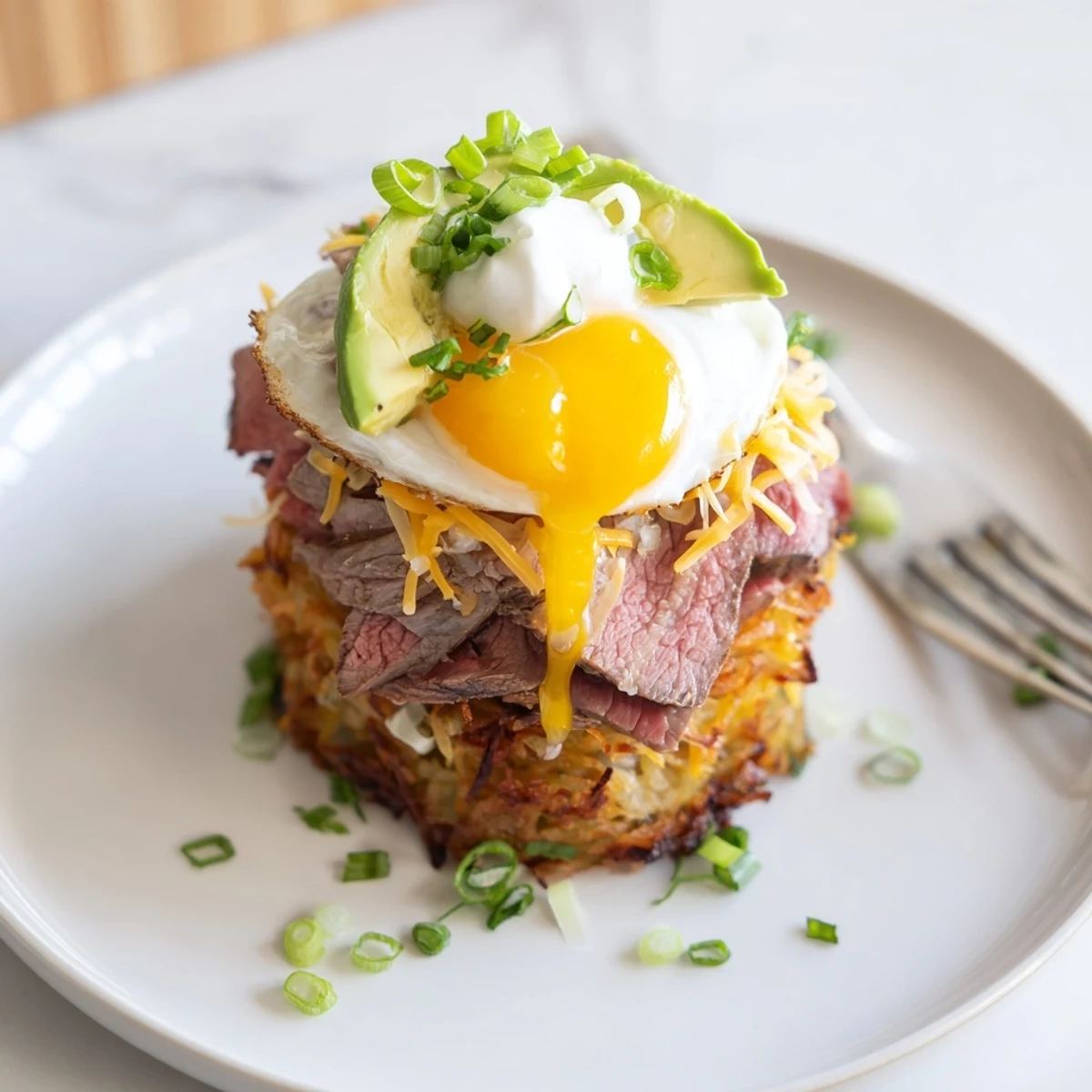 Plate of Loaded Steak Egg Hash Brown Stacks, sizzling steak and crispy potatoes