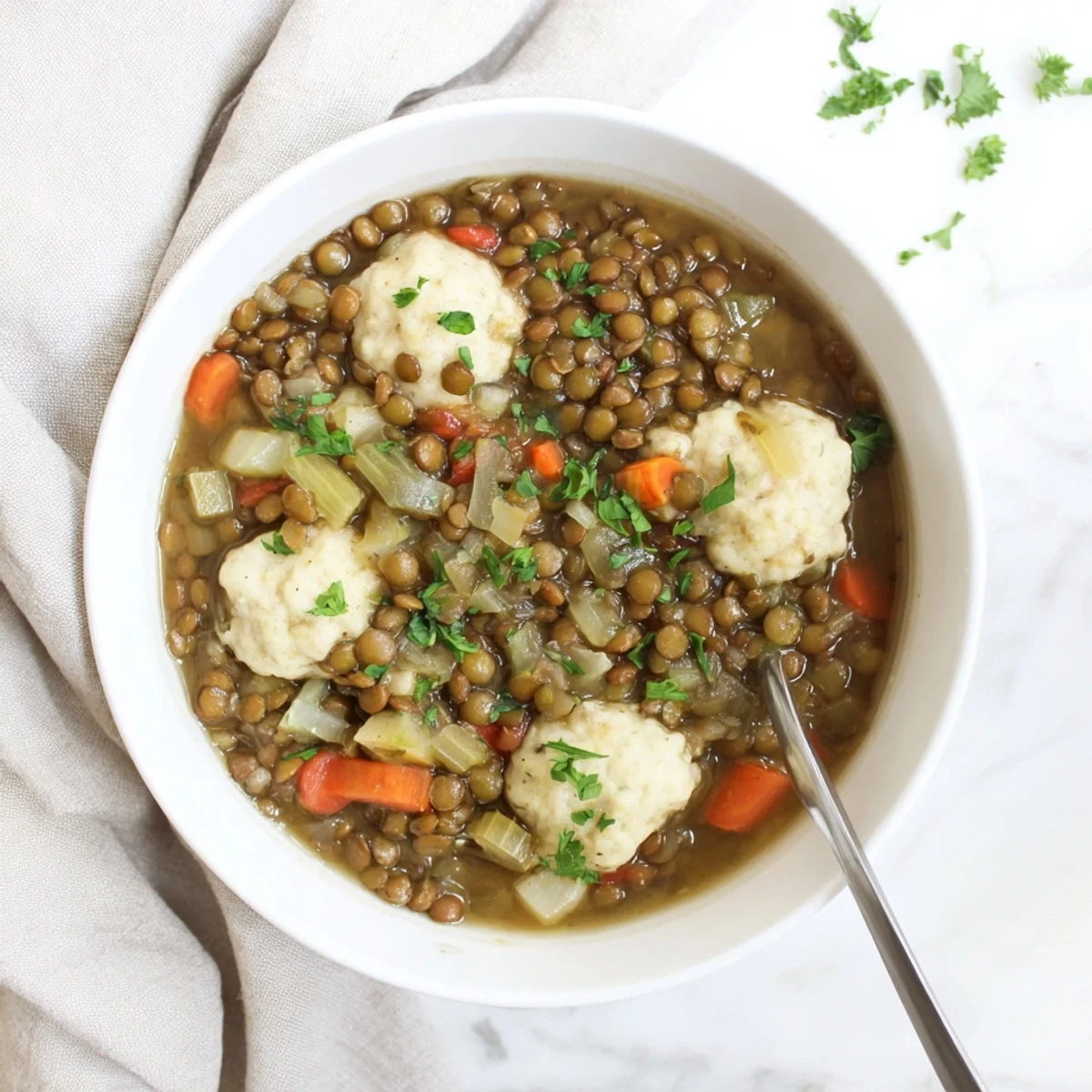 Comforting bowl of lentils with dumplings featuring tender vegetables in rich vegetable broth