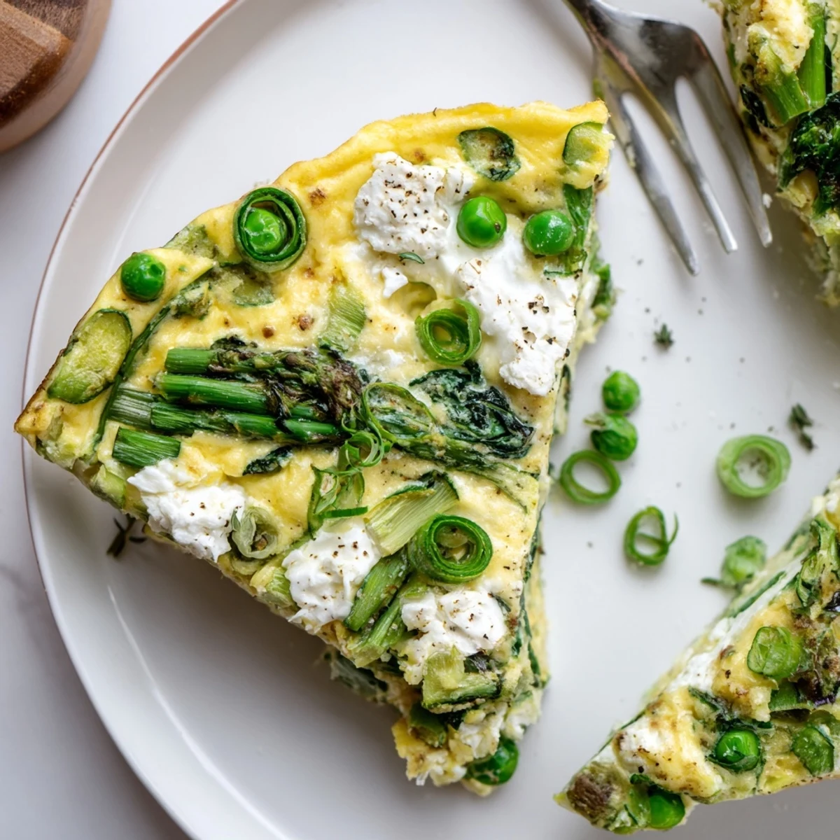 Oven-browned Spring Vegetable Frittata With Goat Cheese served warm on rustic skillet