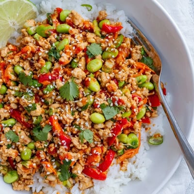 Steaming ground turkey rice bowls topped with fresh cilantro green onions and sesame seeds